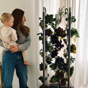 Woman holding child next to Gardyn Home